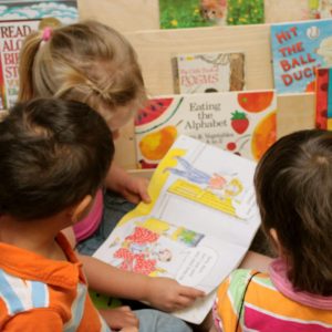 Girl reading to other children